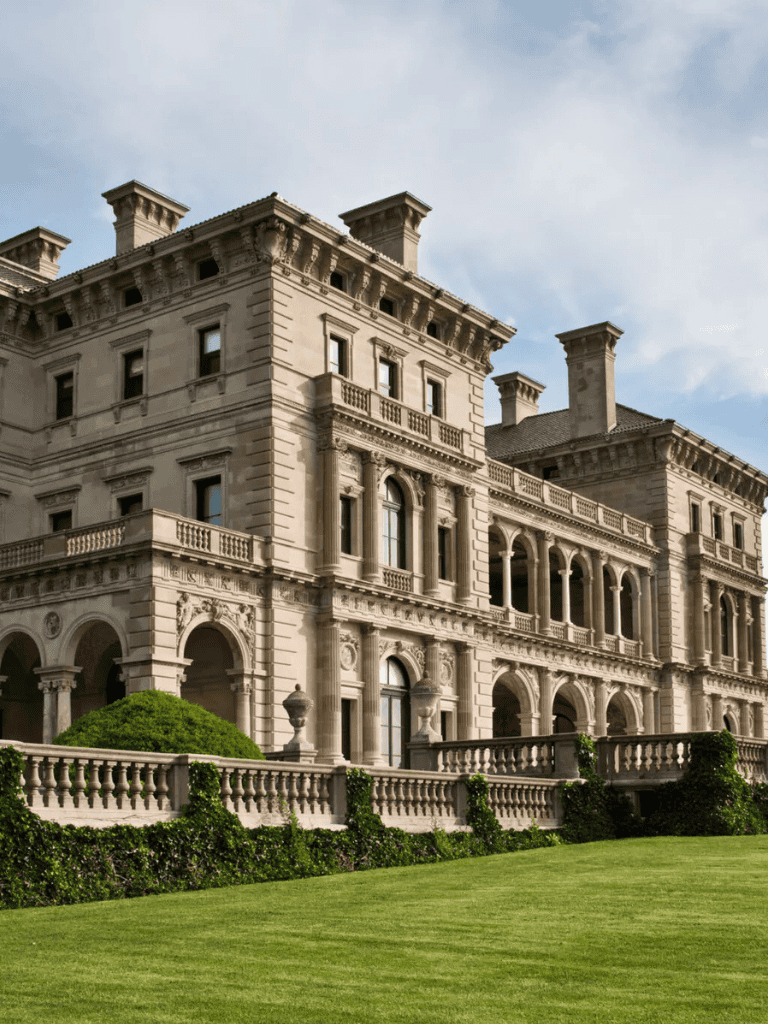 Luxurious historic mansion with elegant architecture and lush green lawn.
