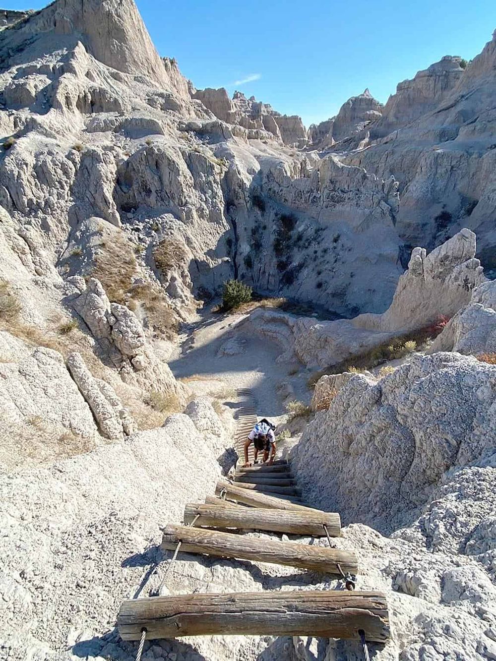 - Rugged mountain trail with wooden ladder steps in white rocky terrain, adventure travel destination.