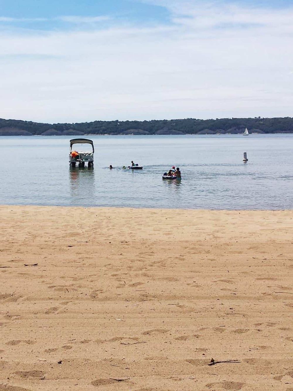 Relaxing lakeside beach with boats, pedal boats, and kayaks, perfect for outdoor adventure and family fun.
