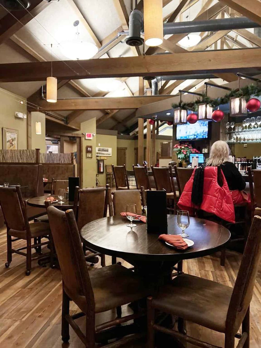 Cozy indoor restaurant with wooden beams, festive holiday decor, and a warm atmosphere, perfect for dining and celebrating.