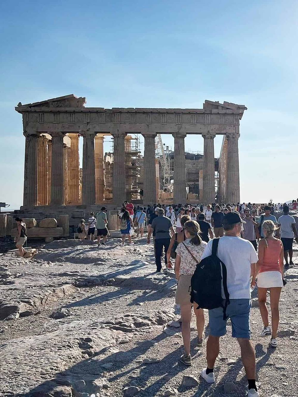 Ancient Parthenon temple at Athens Acropolis with tourists visiting, historical site, Greece travel destination, architecture, ruins, cultural heritage.
