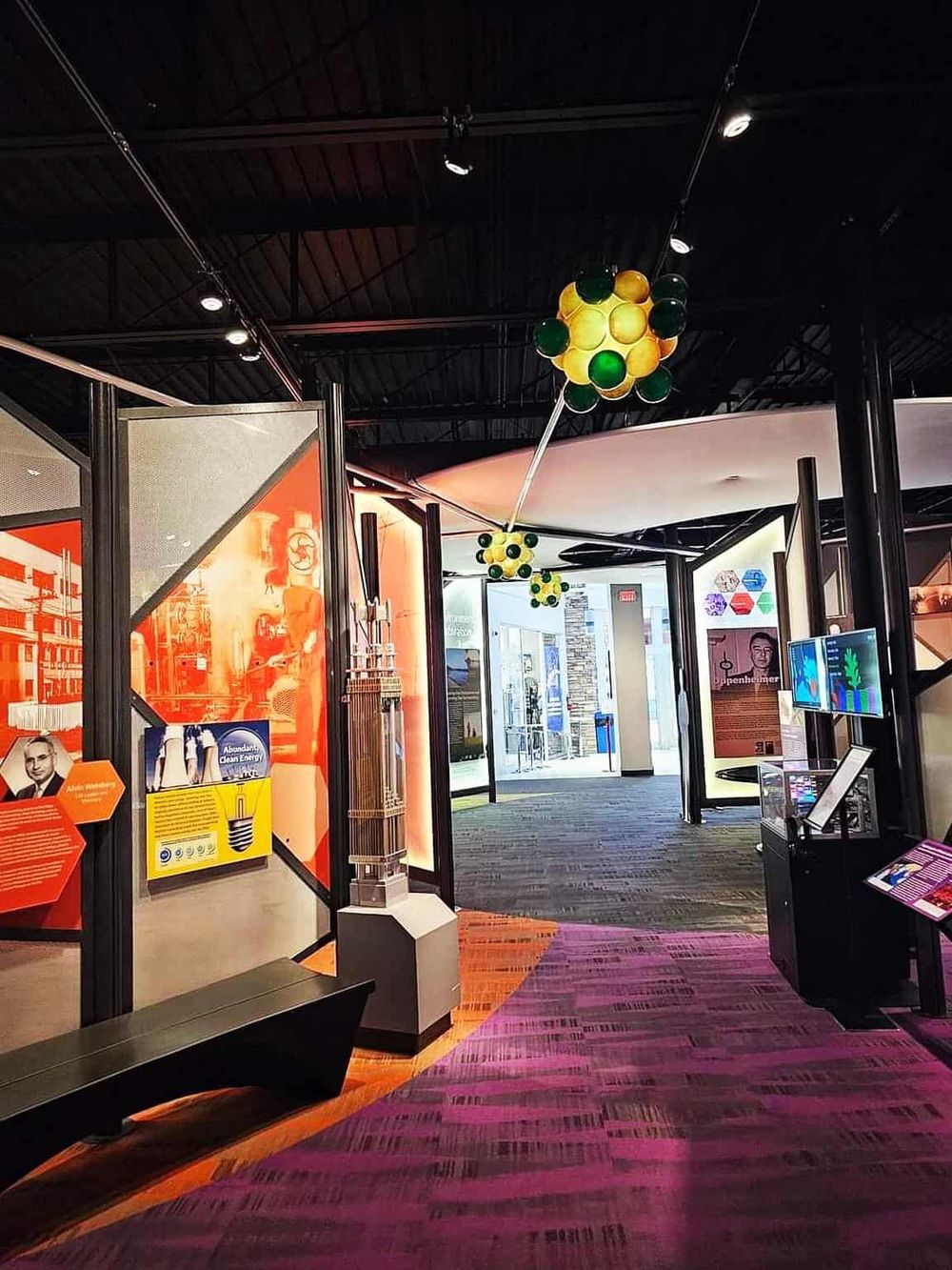 Interactive science exhibit with colorful atomic models and informational displays at QuestForDirections.