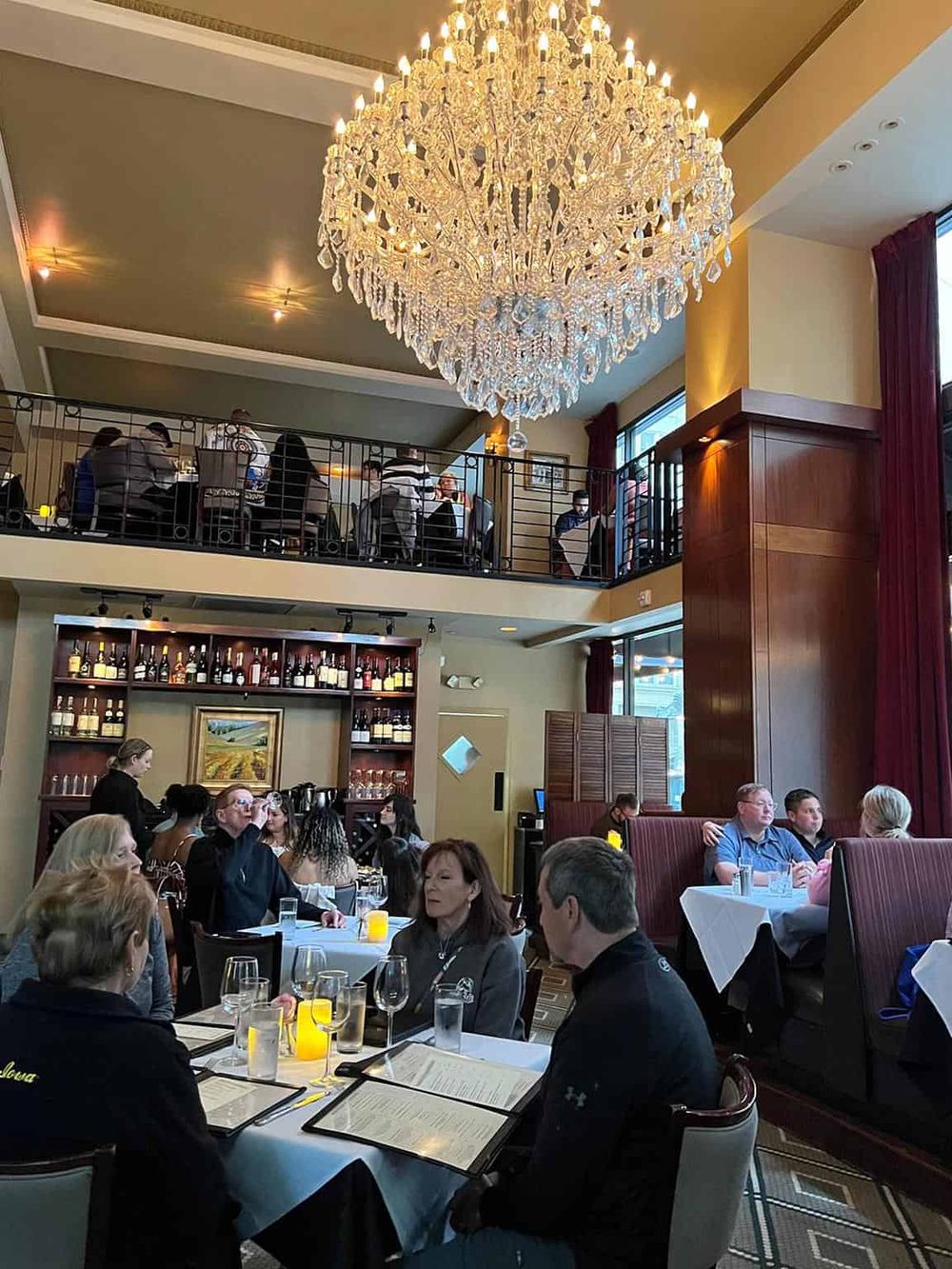 Elegant restaurant interior with chandelier, dining area, and guests enjoying their meal at QuestForDirections.