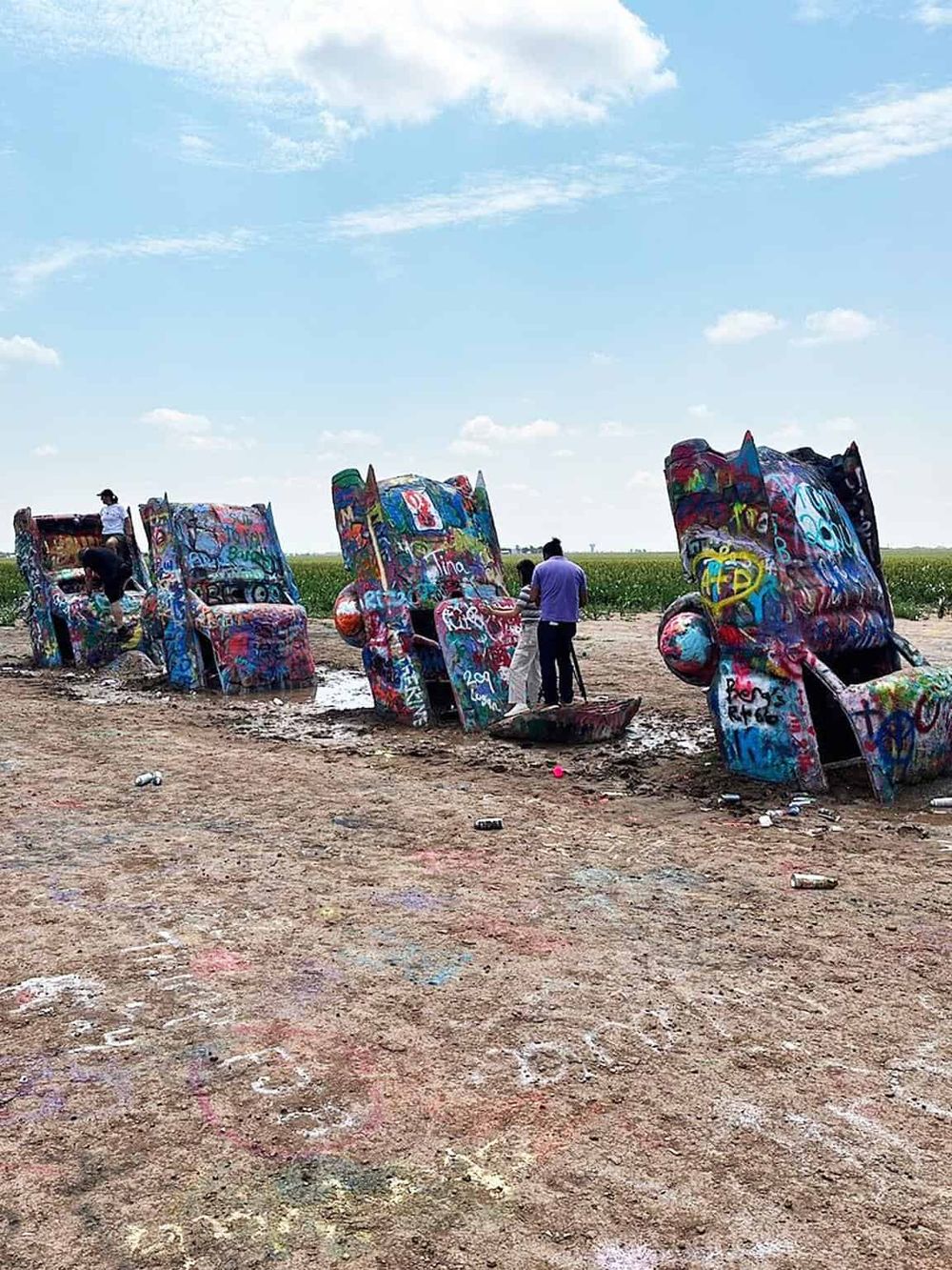 Colorful Graffiti-covered Chair Installations in an Open Field for Art and Exploration.
