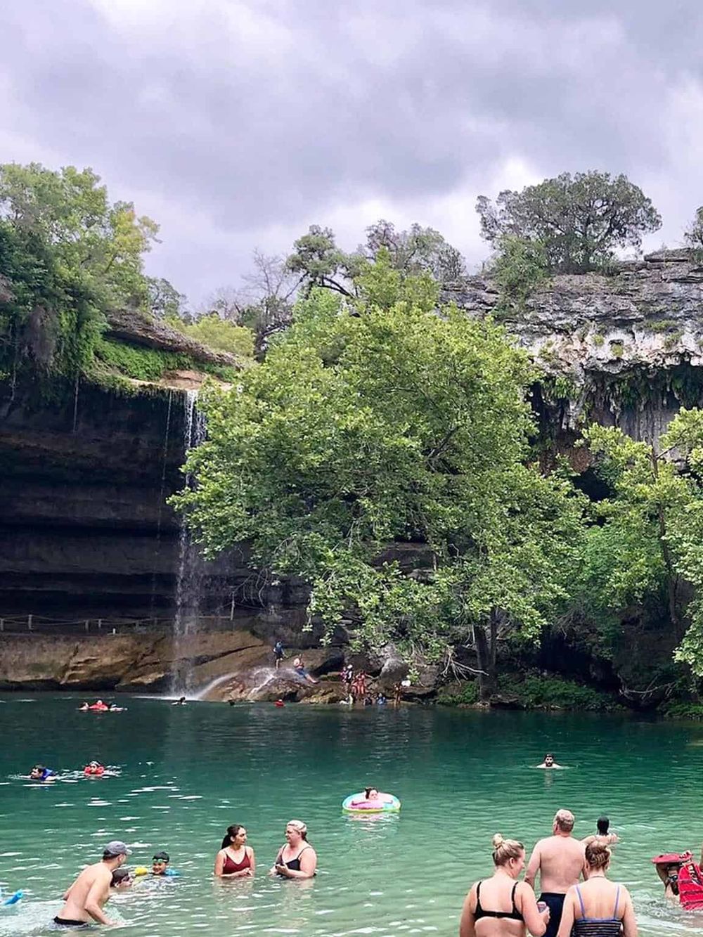 Scenic natural waterfall and swimming area at Quest for Directions outdoor adventure park.