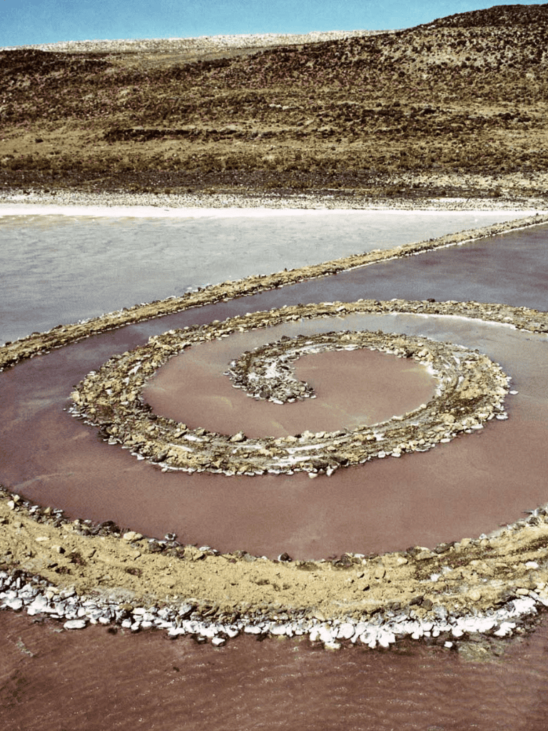 Salt flats with spiral salt formation and scenic landscape at sunrise or sunset.
