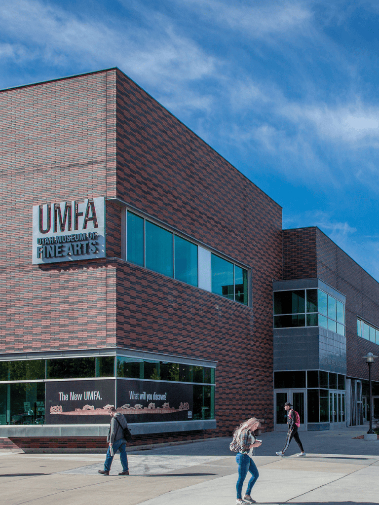 Modern Utah Museum of Fine Arts building exterior with visitors walking in front.