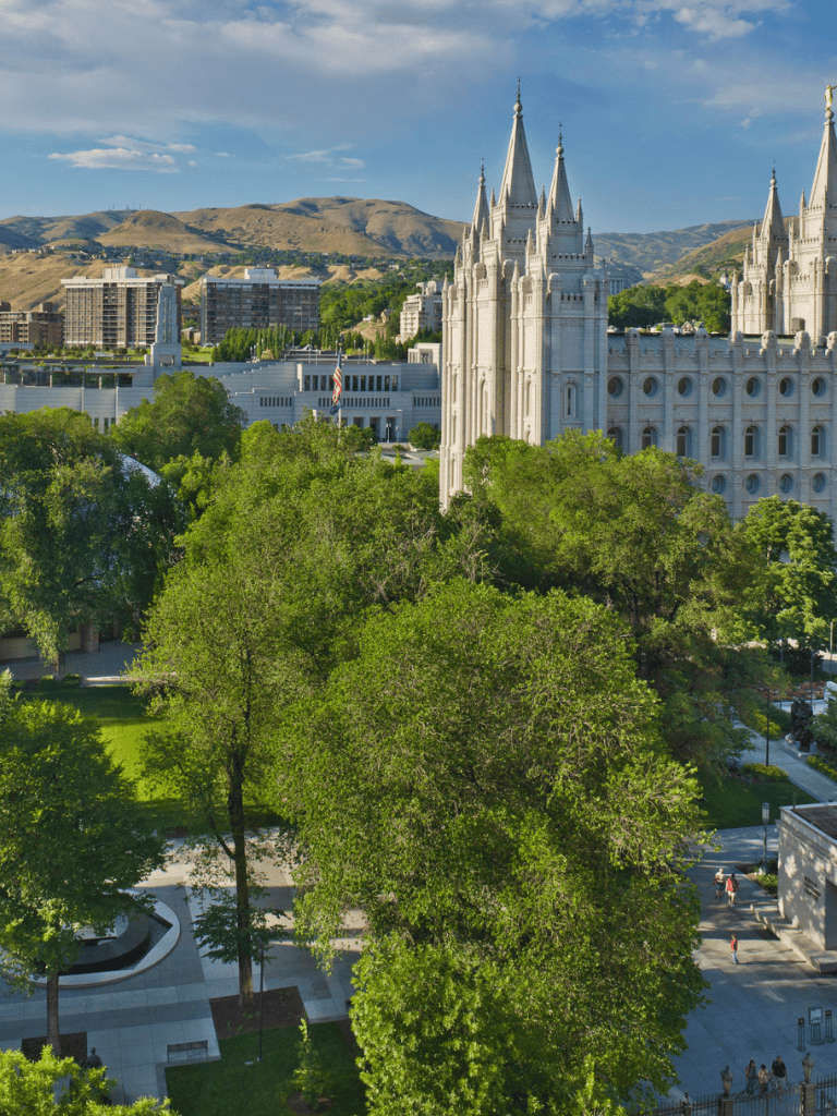 Impressive Salt Lake Temple in downtown Salt Lake City with city skyline and mountains.