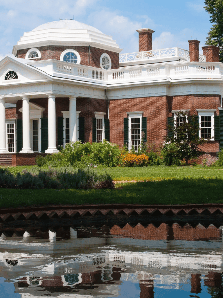 Elegant historic mansion with lush landscaping and water features, ideal for guided tours and architectural exploration.