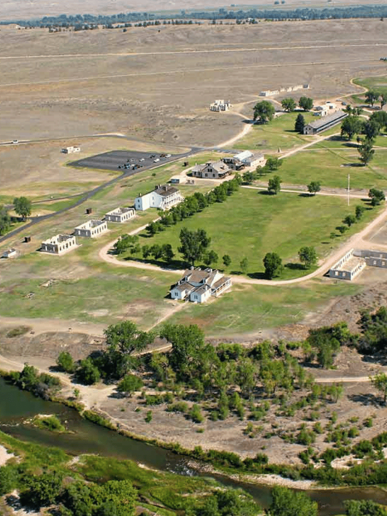 Modern rural community surrounded by open fields and a river, with residential homes and green spaces.