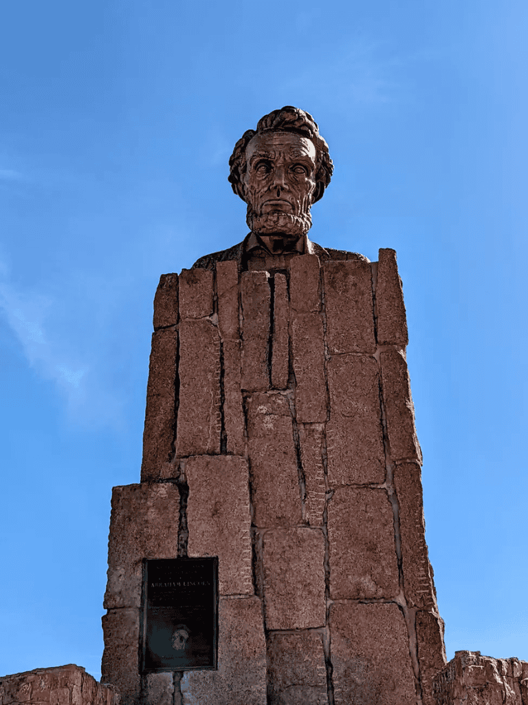 Dante Alighieri statue in Florence, Italy, towering over visitors with a majestic sky background.