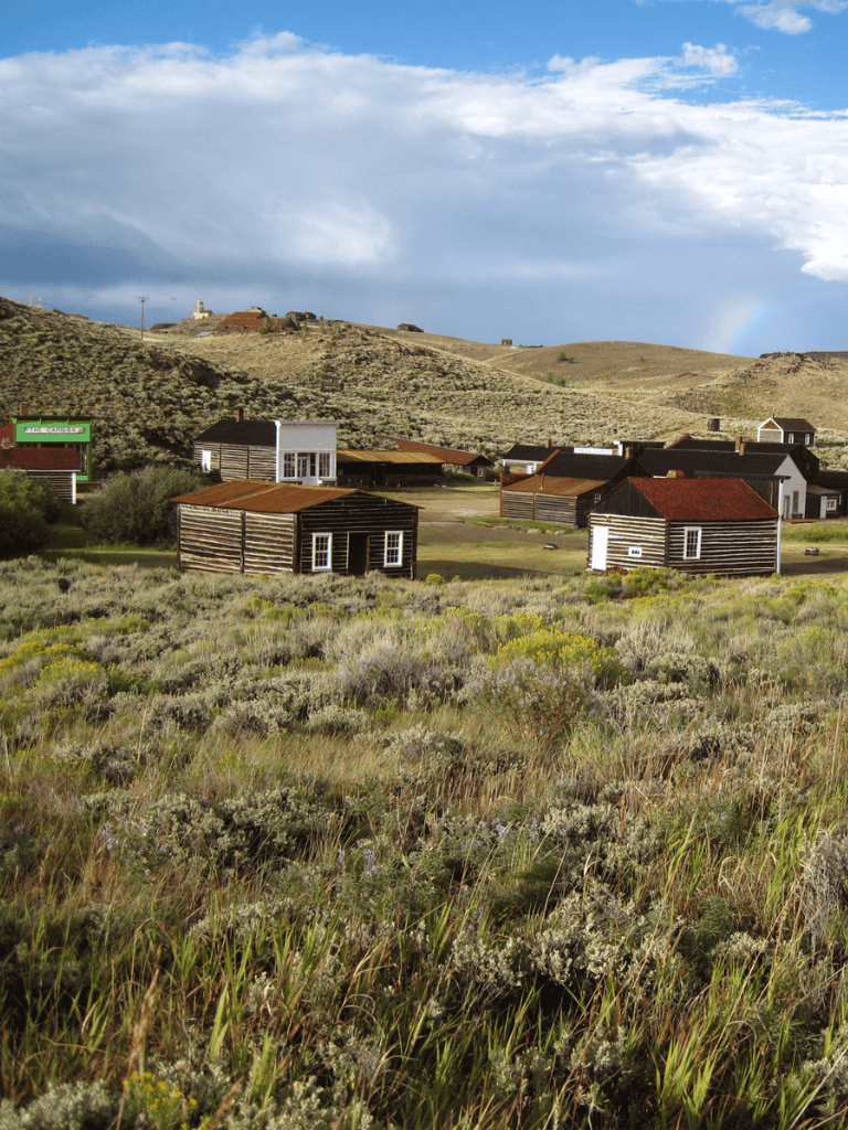 Rustic town with wooden homes and rolling hills, scenic landscape, perfect for travel & adventure.