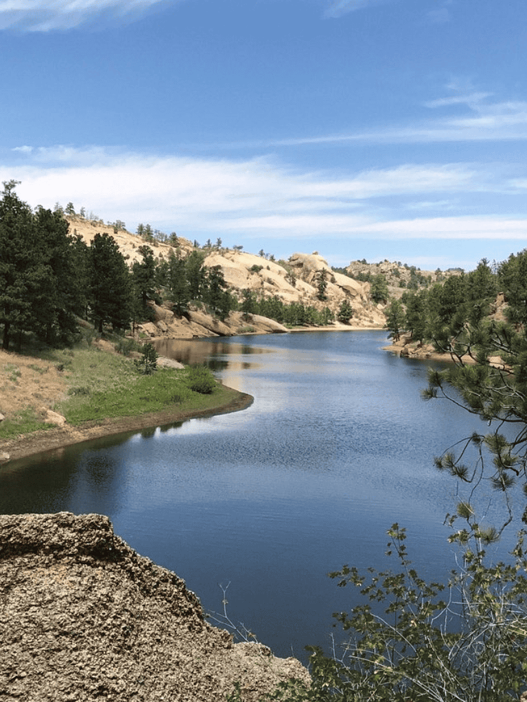 Serene river landscape with trees and rocky hills, perfect for outdoor adventure and nature exploration.