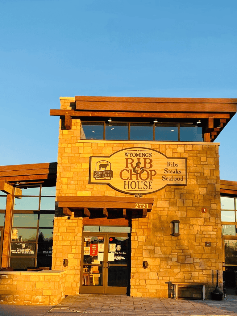 Wyoming's RIB & CHOP House restaurant in a rustic stone building with large windows, serving ribs, steaks, and seafood.