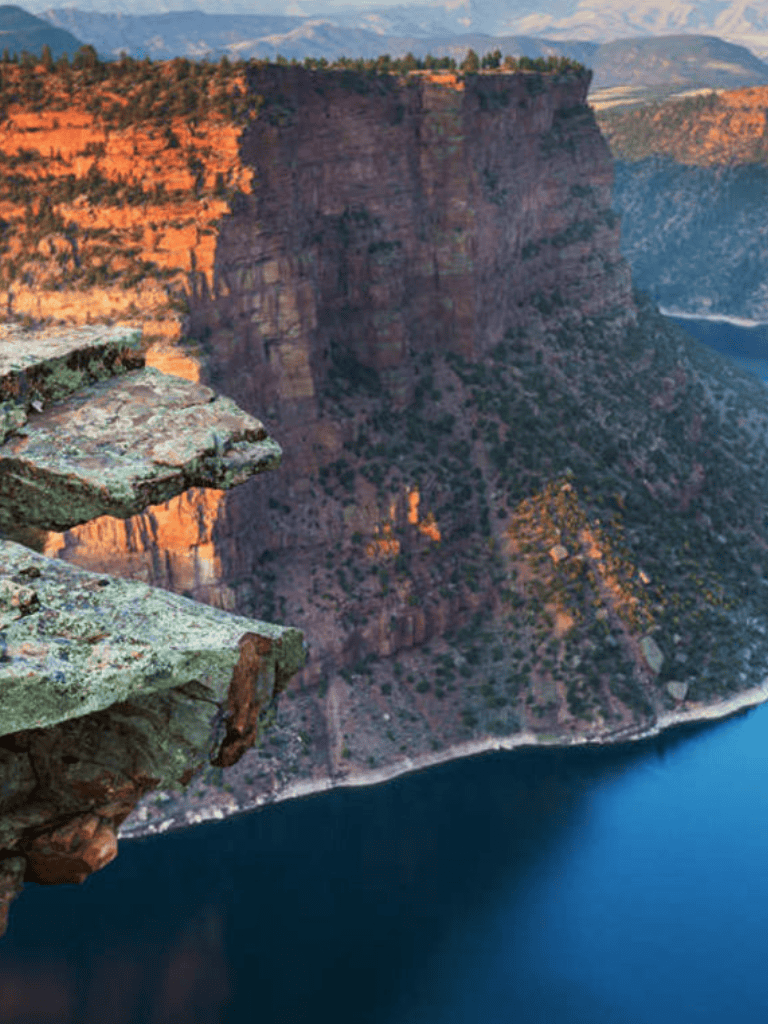 Breathtaking canyon cliff view overlooking a river at sunset.