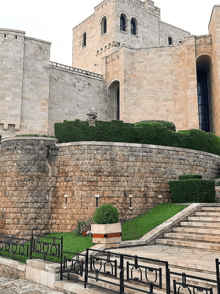 Majestic castle with stone walls and green manicured landscaping, modern architecture, and historic appeal.