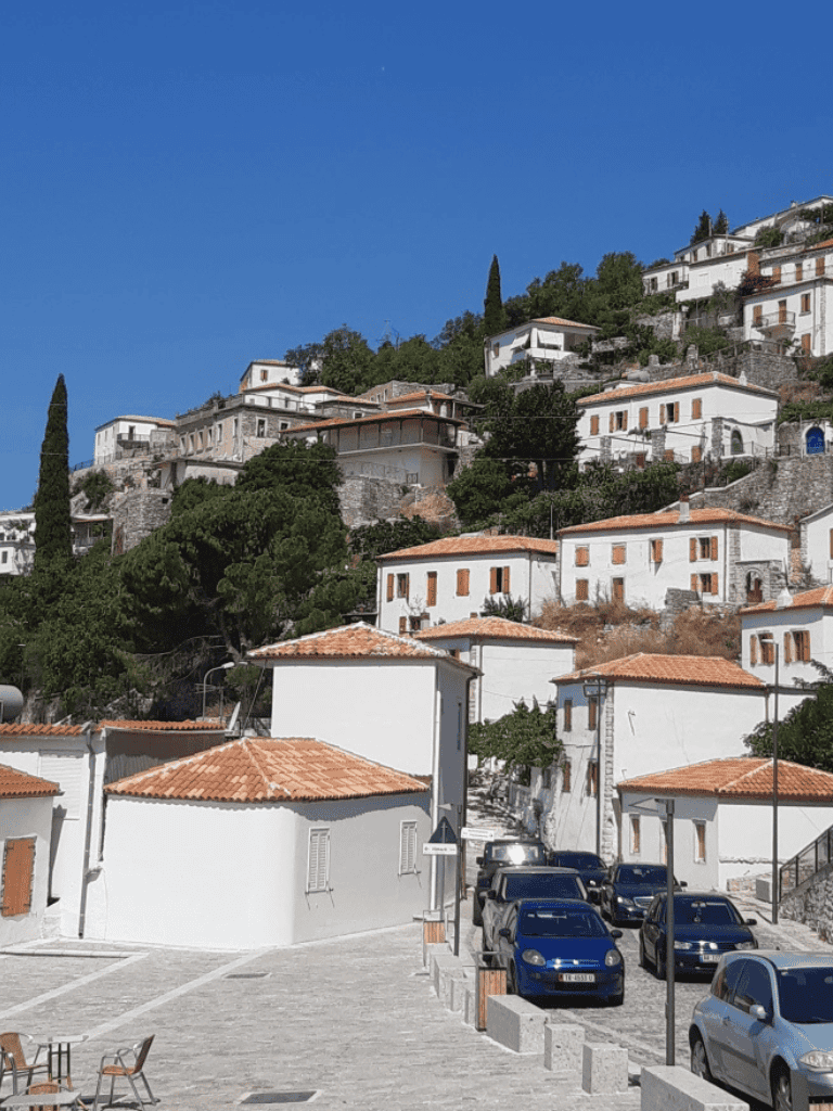 Traditional hillside houses with terracotta roofs in a scenic coastal village.
