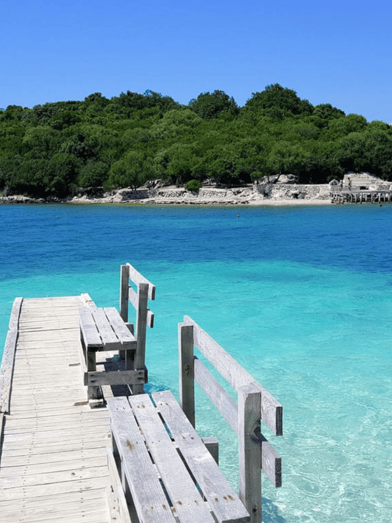 Tranquil seaside retreat with wooden dock and clear blue waters.