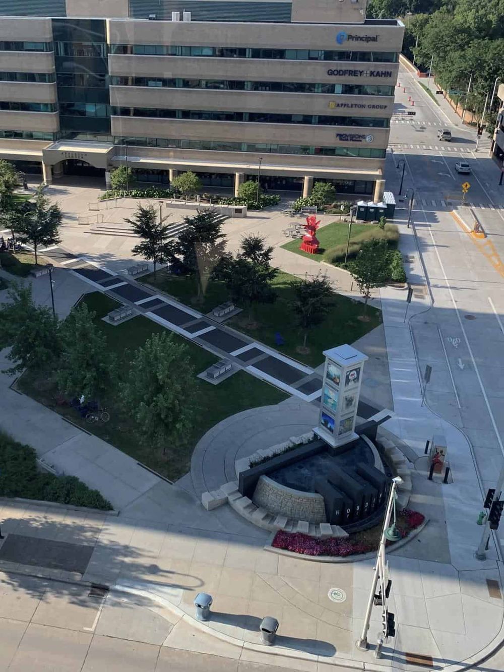 Modern office building with urban park and water fountain in downtown area.