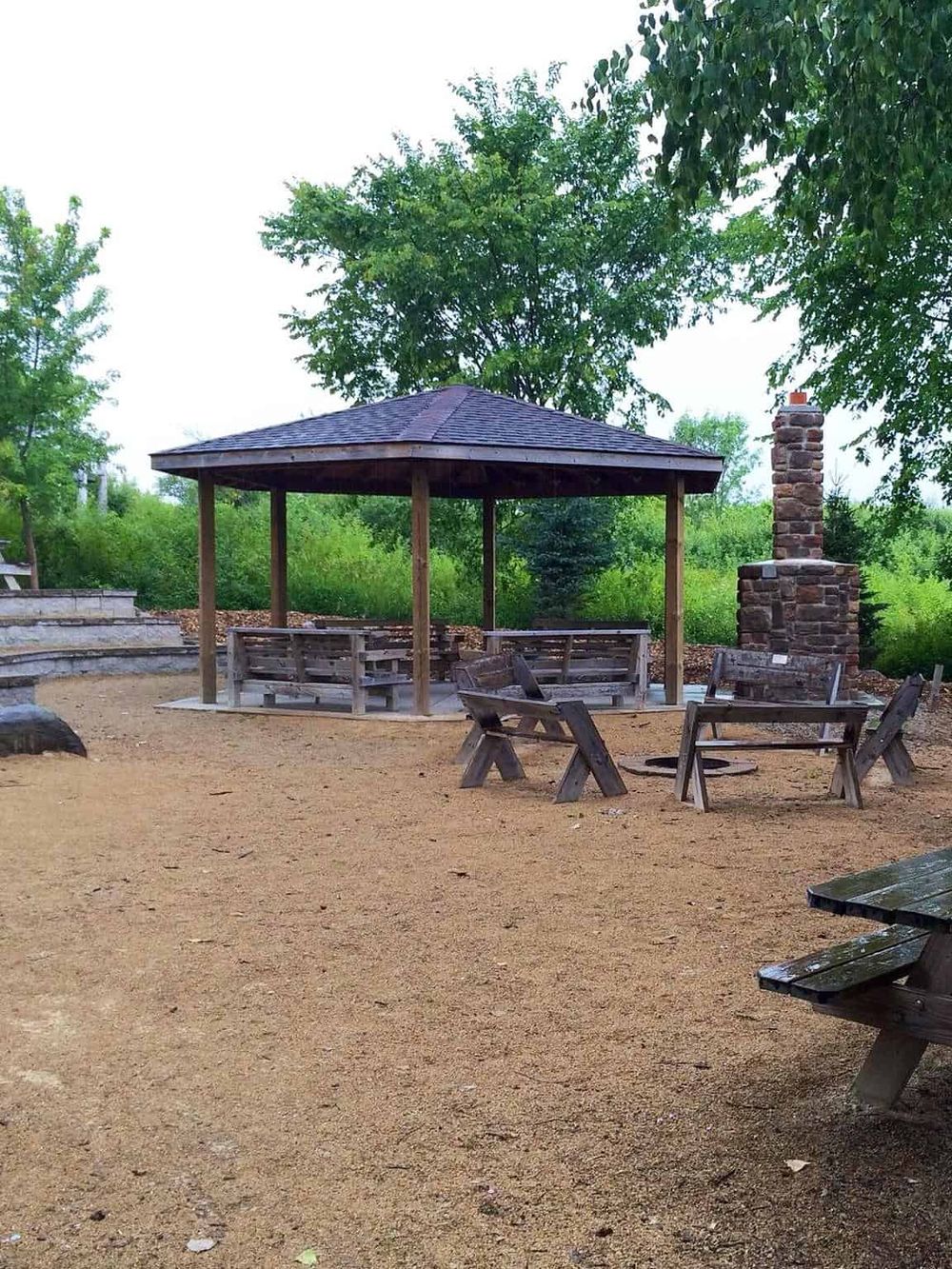 Outdoor picnic area with wooden benches and a pavilion at QuestForDirections.
