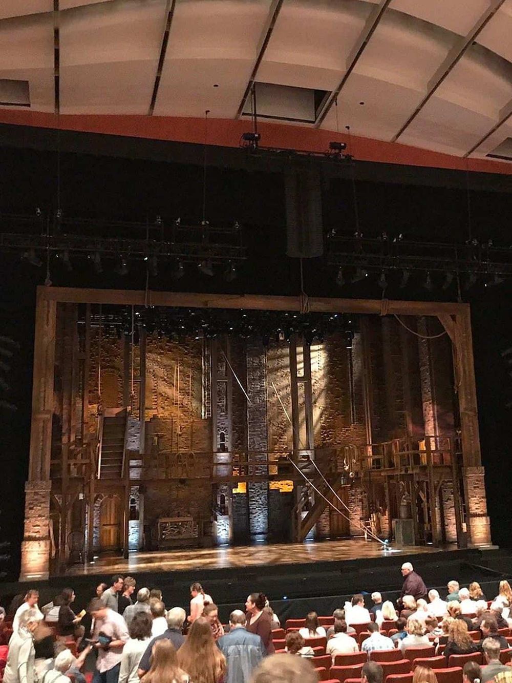 Impressive theater stage set for a performance at Quest for Directions. Audience members gather for an engaging cultural event.