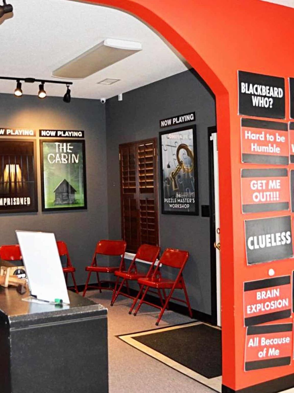 Brightly lit escape room with themed posters and red chairs, perfect for team building and fun puzzles.