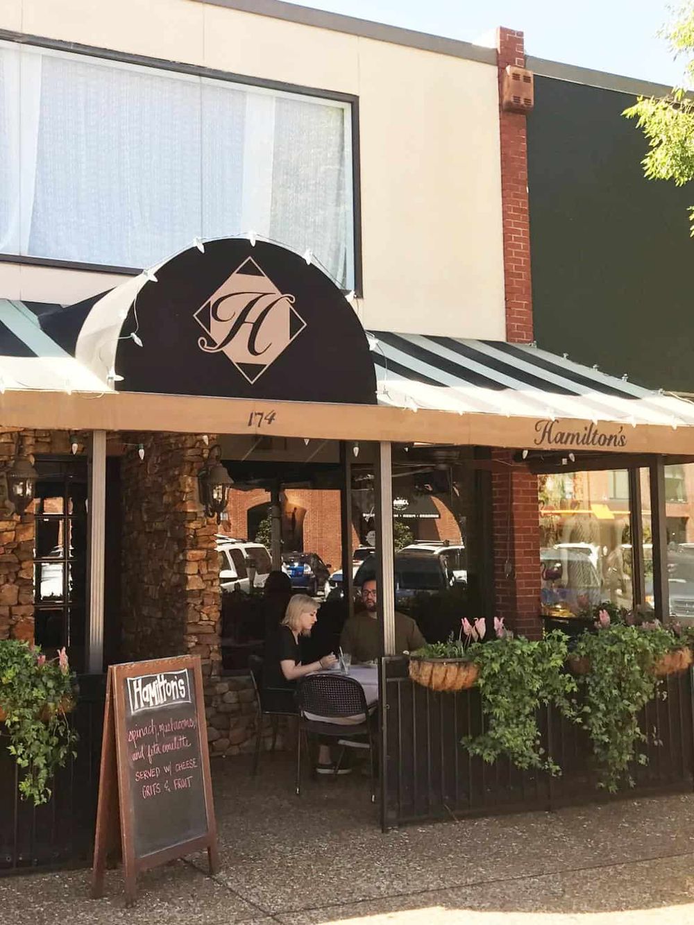 Charming outdoor dining at Hamilton's restaurant with friends, featuring a cozy patio and delicious food options.