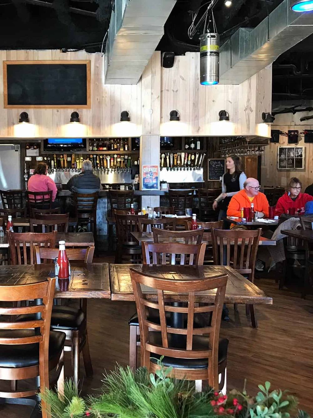 Cozy pub interior with wooden furniture, bar area, and natural lighting, perfect for enjoying craft beers and casual dining.