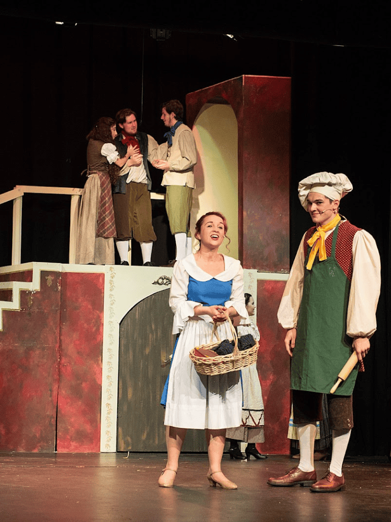 Charming theater scene with actors in period costumes performing a classic play, highlighting theatrical arts and storytelling.