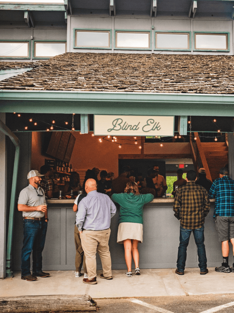 Beer bar at Blind Elk with patrons enjoying drinks and socializing.