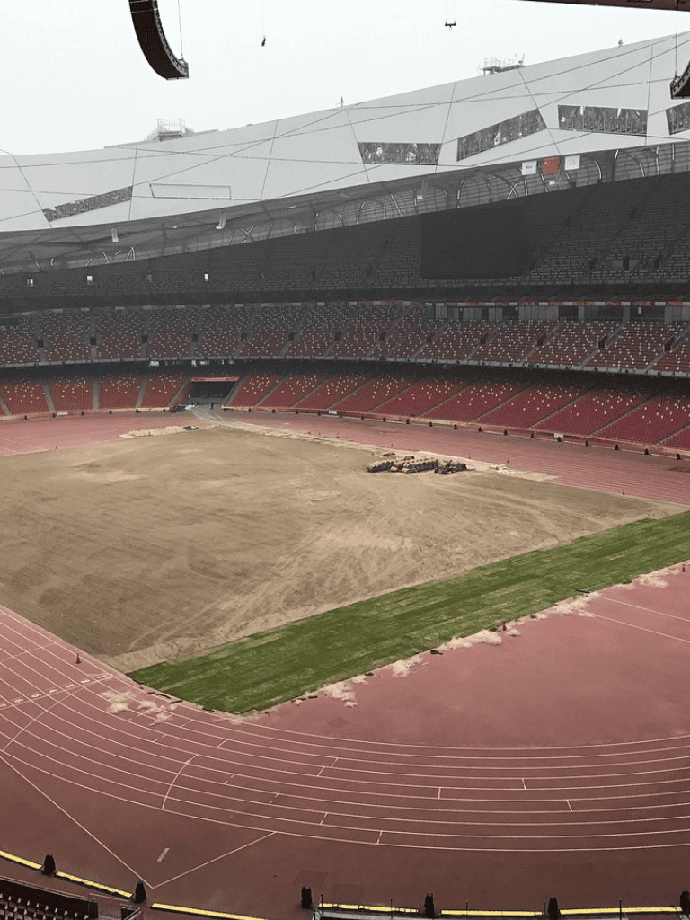 New stadium under construction with a running track and field area.