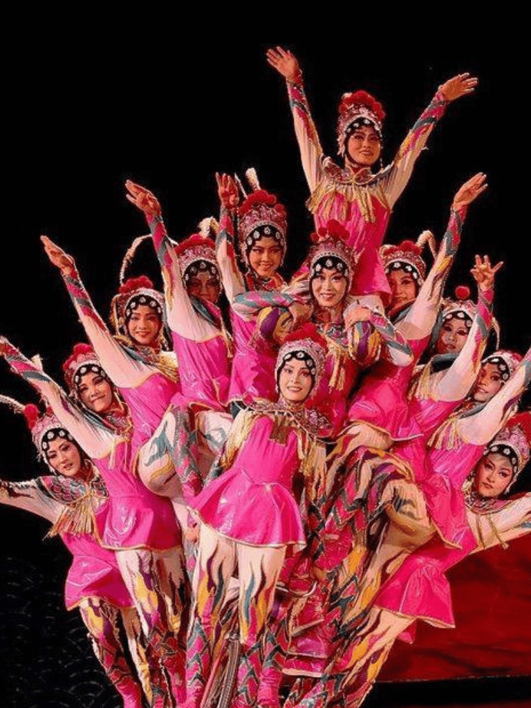 Colorful traditional dance performers in vibrant costumes on stage.