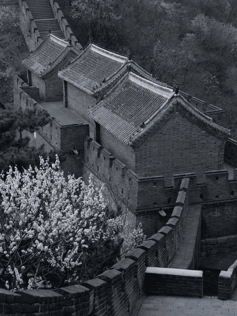 Ancient Chinese architecture on the Great Wall of China with traditional styled rooftops and stairs.