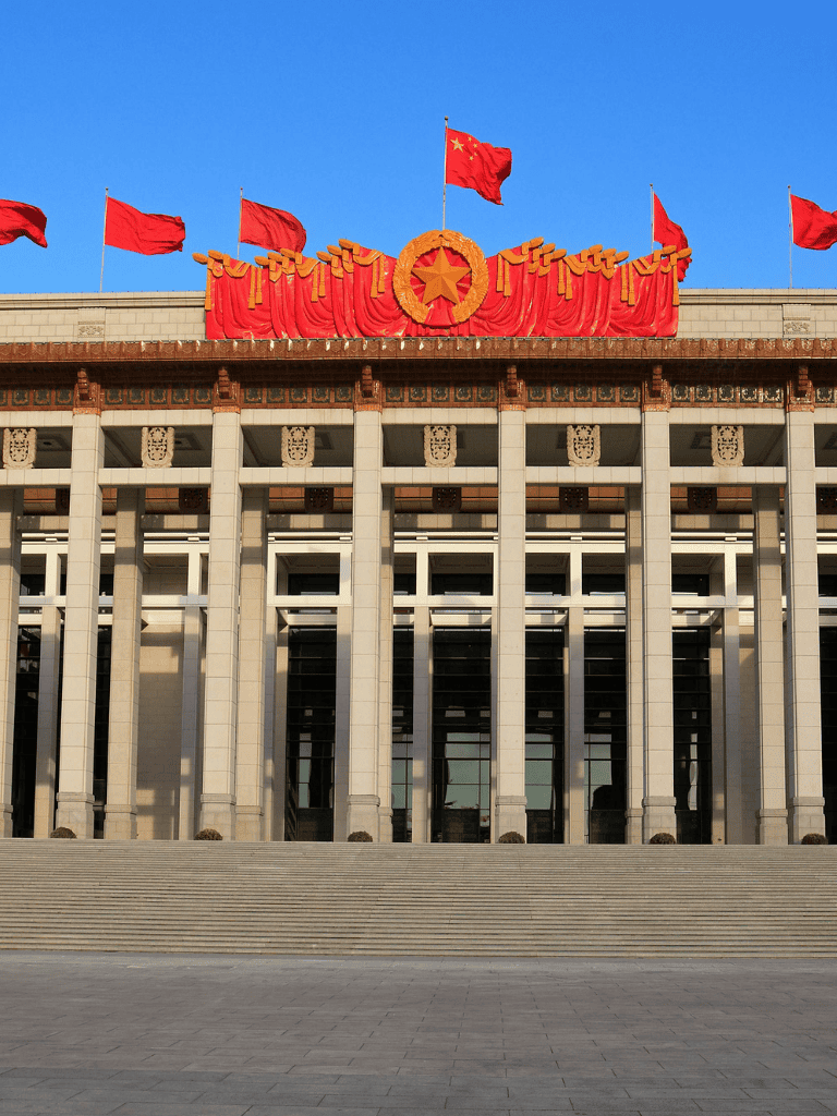 Red flags flying above Chinese government building in Beijing, showcasing national pride and political significance.