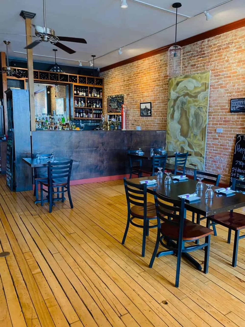 Cozy restaurant interior with brick walls, wooden floors, and modern decor, perfect for a memorable dining experience.
