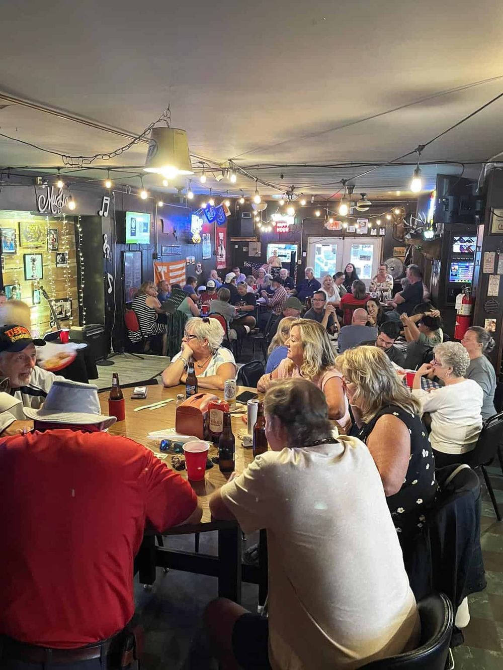 Vibrant bar and restaurant scene with patrons enjoying drinks and socializing.
