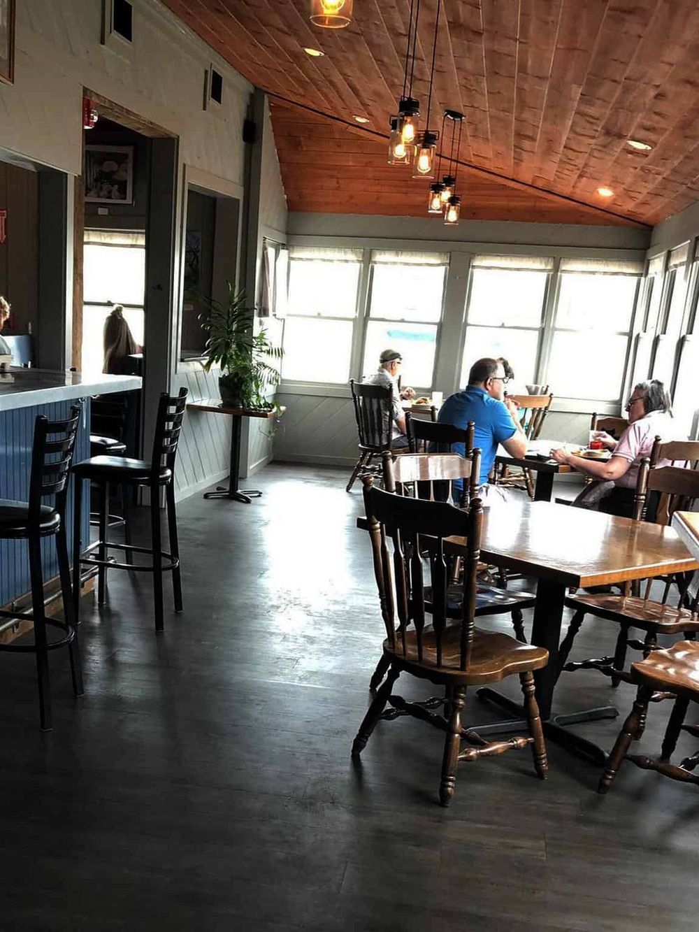 Cozy restaurant interior with wooden accents and large windows, perfect for a flavorful dining experience with QuestForDirections.