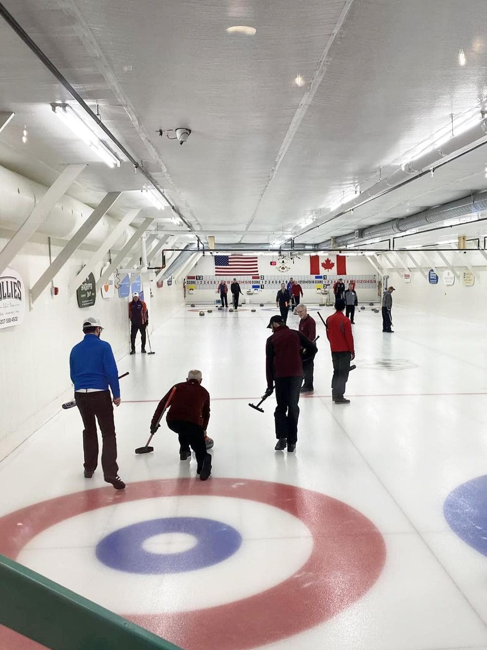Indoor curling rink for fun and recreation, with players engaging in the sport.
