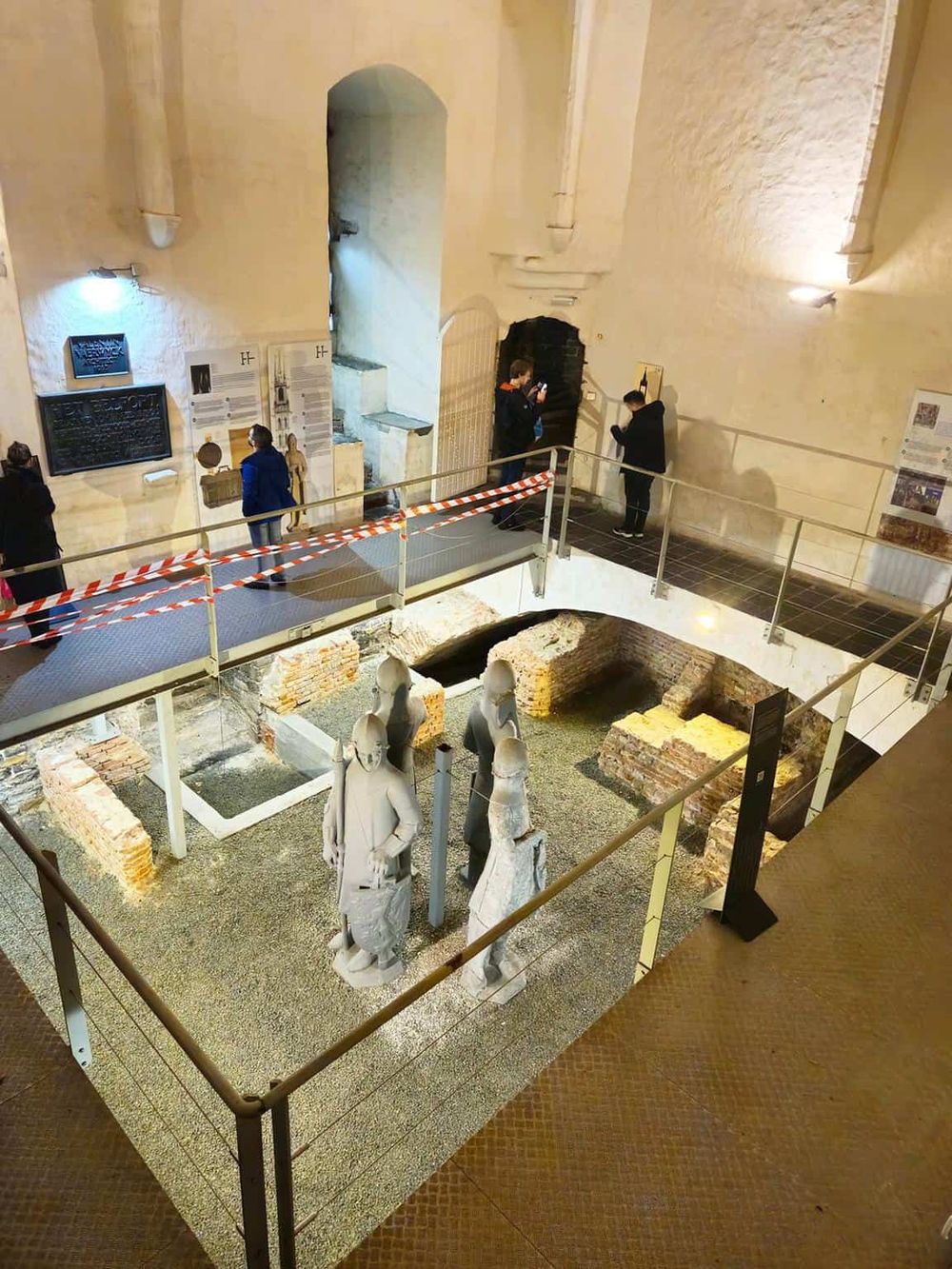 Ancient ruins exhibit with sculptures and historical displays inside a museum.