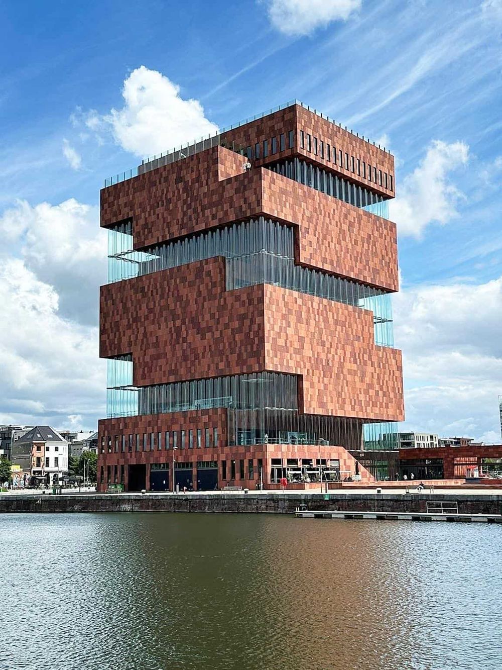 Modern architectural building overlooking water, innovative design, and vibrant cityscape.