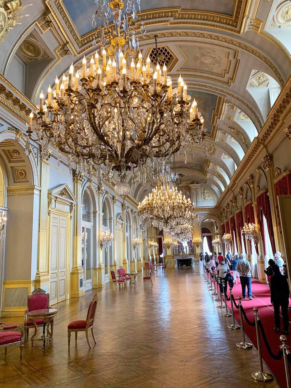 Elegant palace interior with grand chandeliers and ornate gold details.