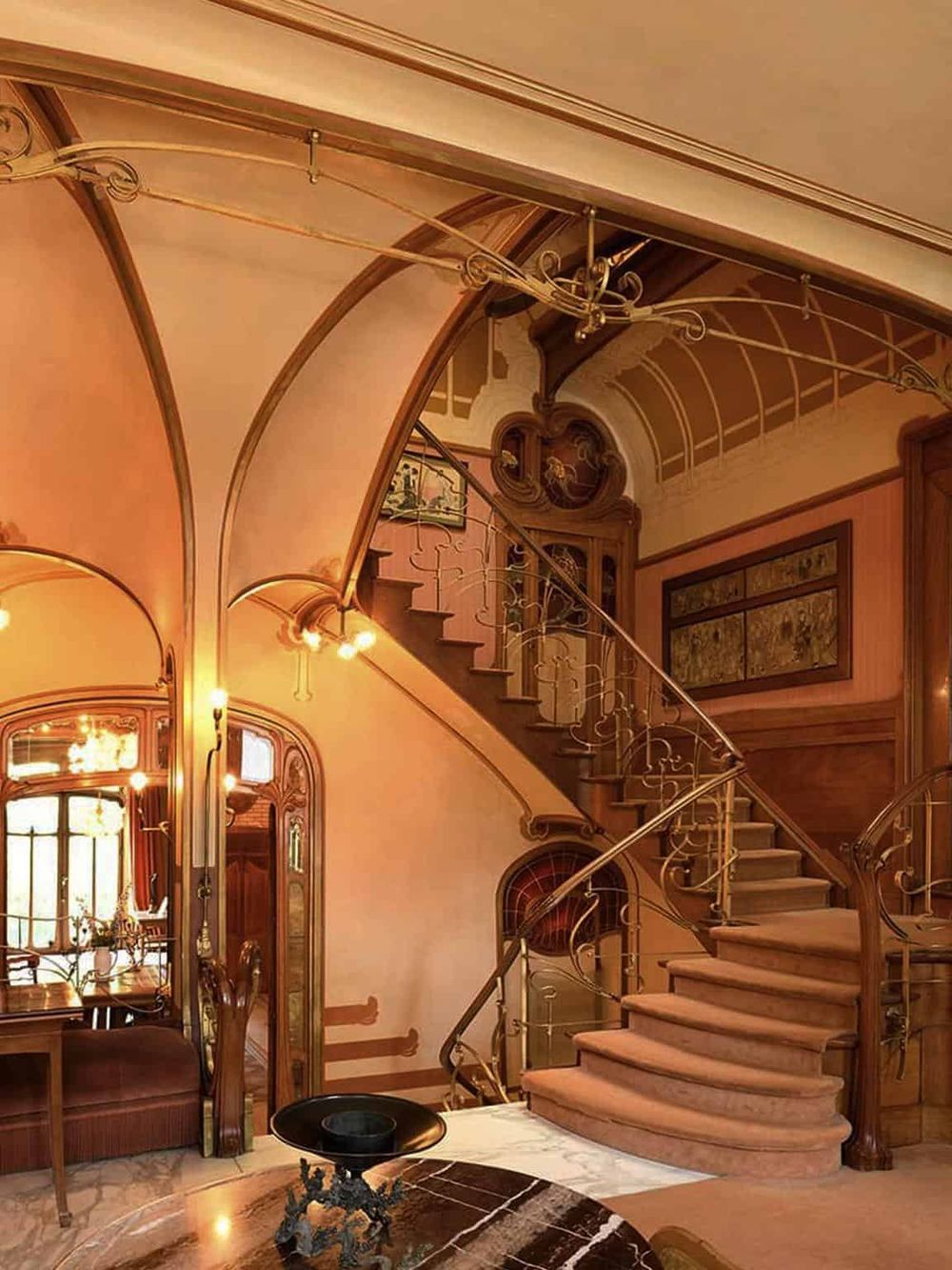 Elegant vintage staircase in luxurious interior with ornate railing and warm lighting.