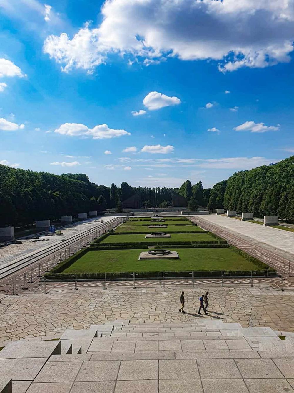 Vivid image of a historic memorial site with lush greenery and bright blue sky, perfect for navigation and travel guides.