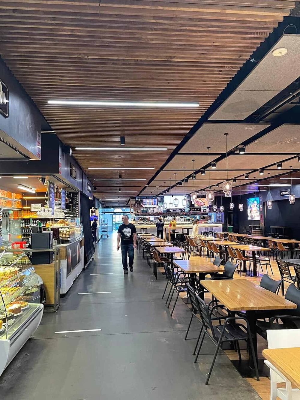 Modern shopping mall food court with seating and food vendors, perfect for dining and shopping excursions.