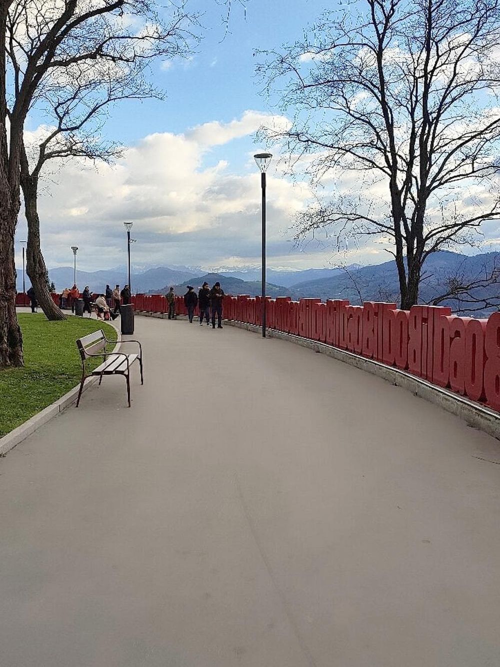 Scenic viewpoint with walking path, trees, and mountain views for outdoor exploration and travel.