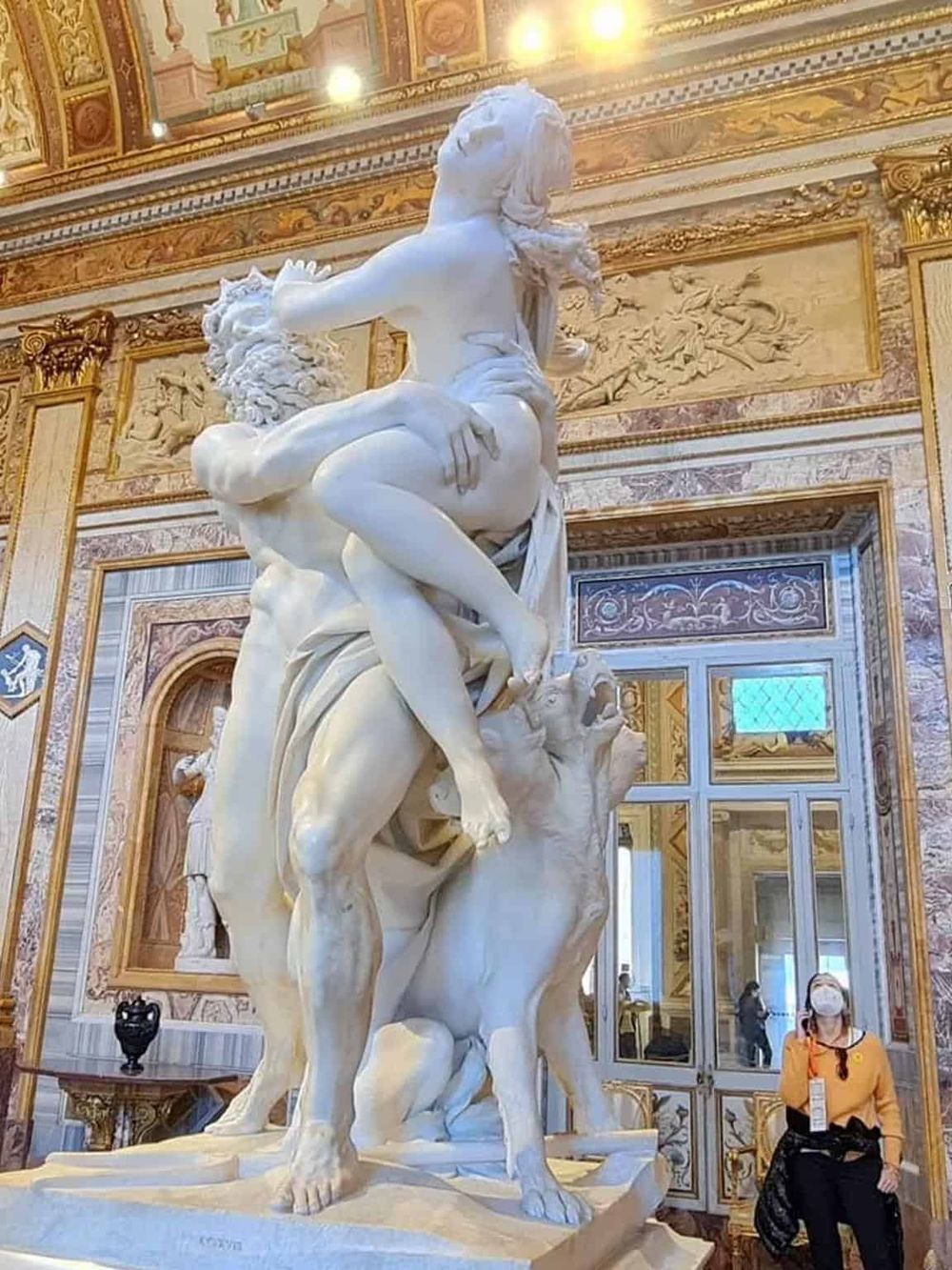 Intricate marble sculpture of mythological figures in ornate palace interior, highlighting artistic mastery.