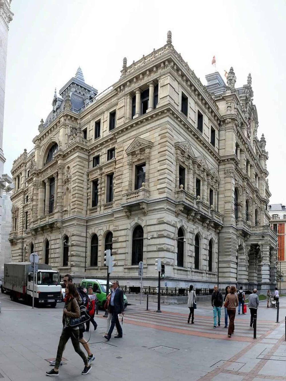 Imposing historic building with intricate architecture in a busy city street.
