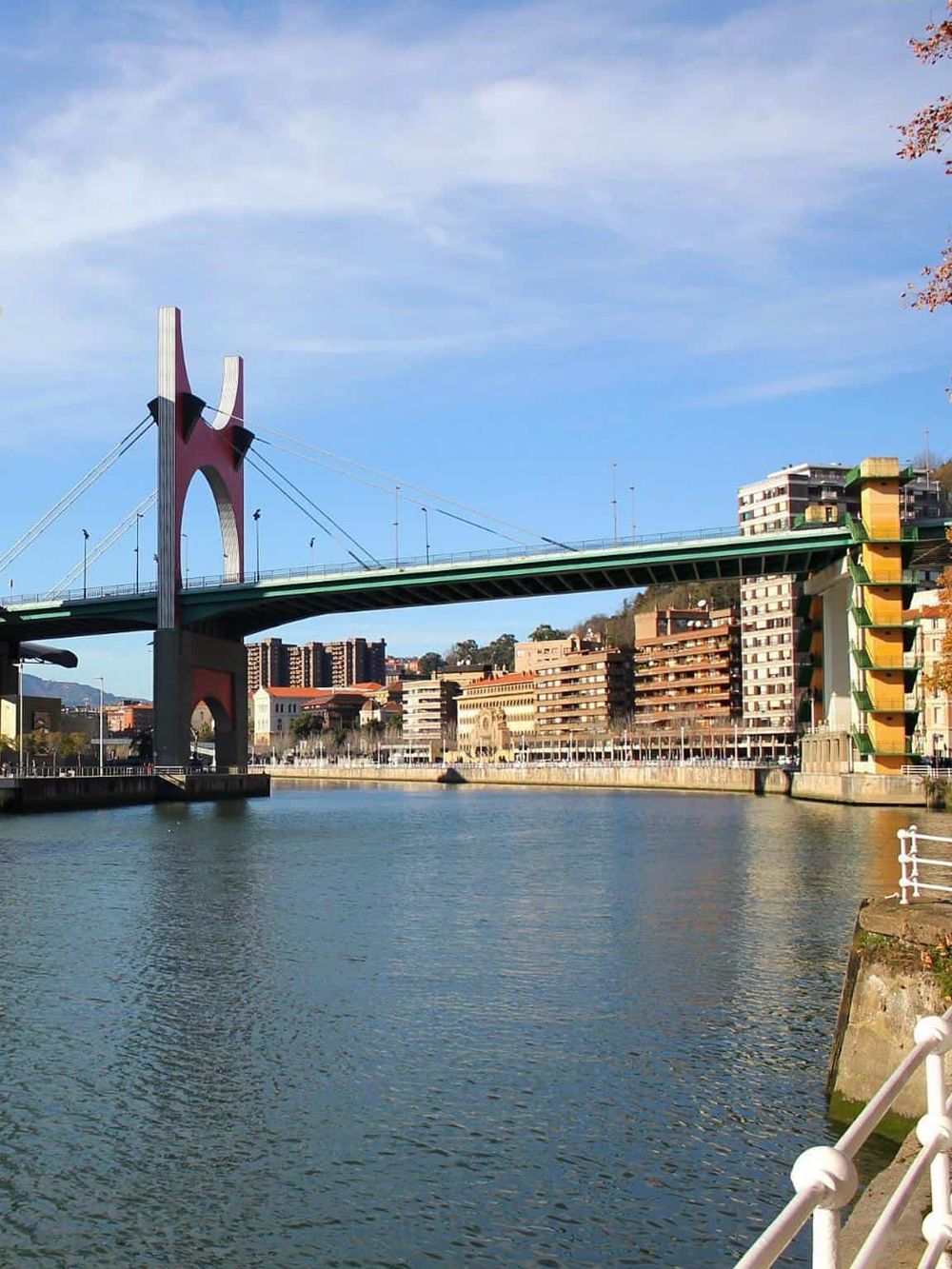 Bridge over a city river with modern buildings, scenic urban landscape, popular city navigation point.