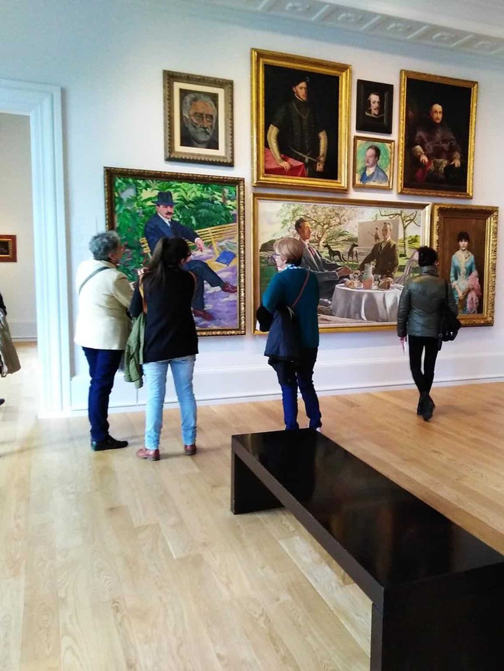 Colorful art gallery with visitors admiring classic paintings and portraits at QuestForDirections museum.