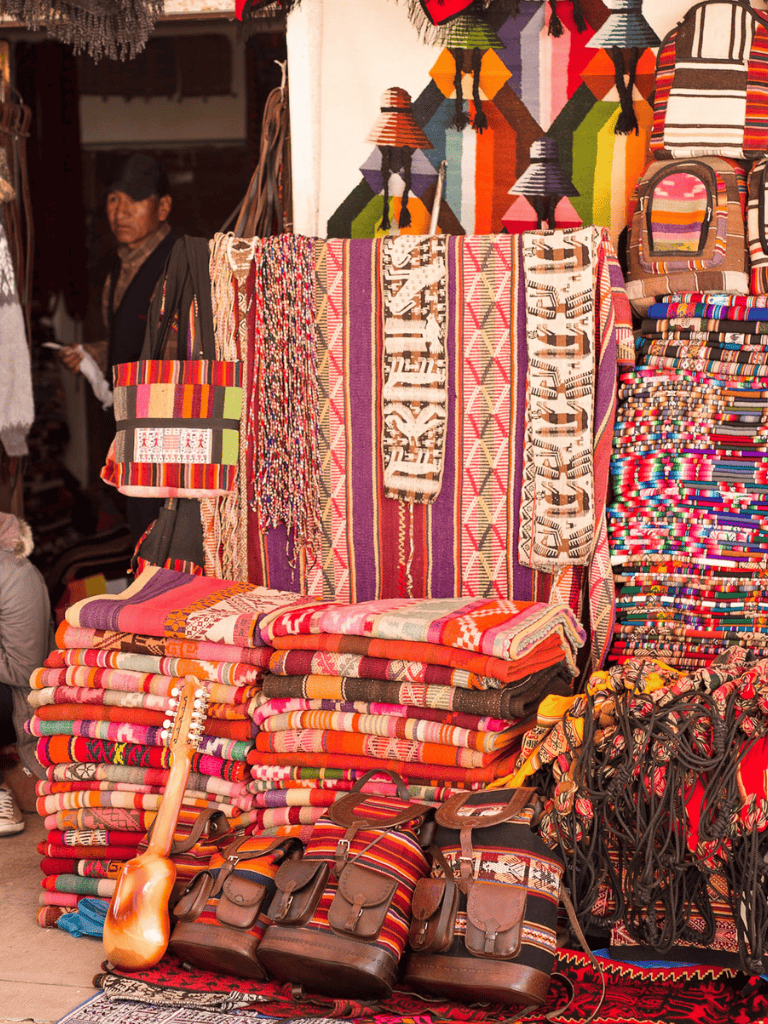 Colorful handmade textile and woven bags at a market stall in Mexico.